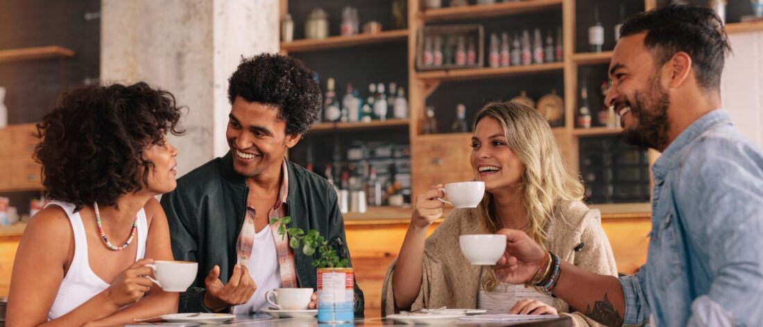 Groepje pratende mensen aan tafel in café: wat doe jij voor werk?