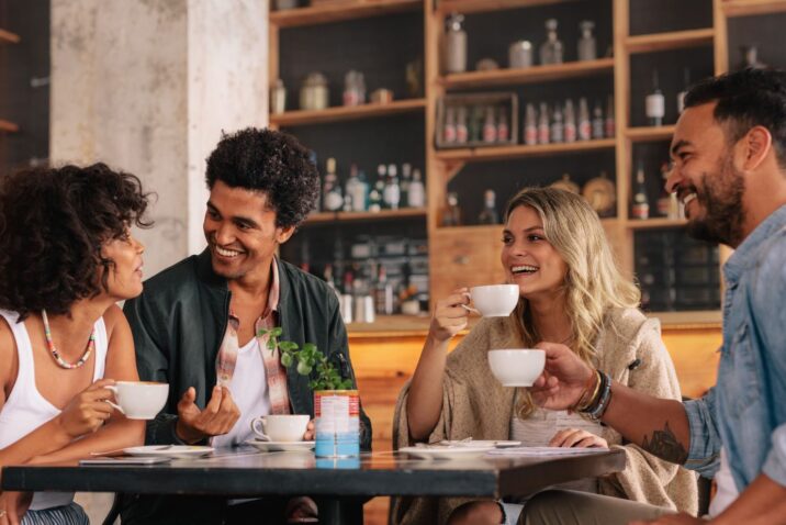Groepje pratende mensen aan tafel in café: wat doe jij voor werk?